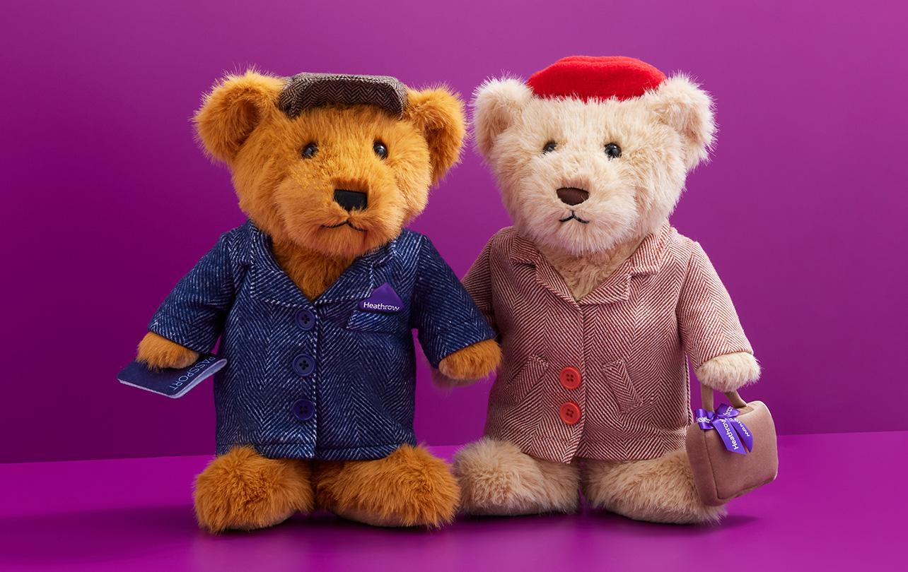 two plush toy bears, one with a denim jacket, the other with a pink coat and handbag