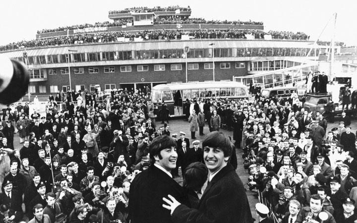 Beatles surrounded by thousands of fans