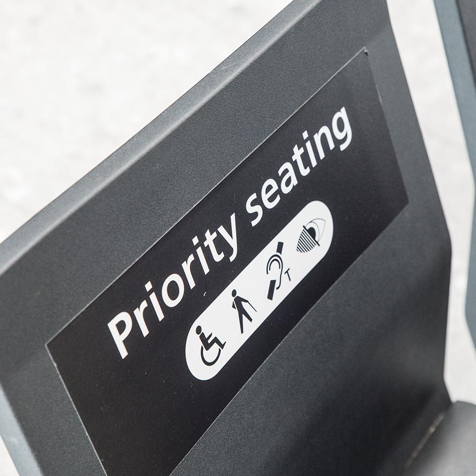 Priority seating area marked with a sign and a wheelchair icon.