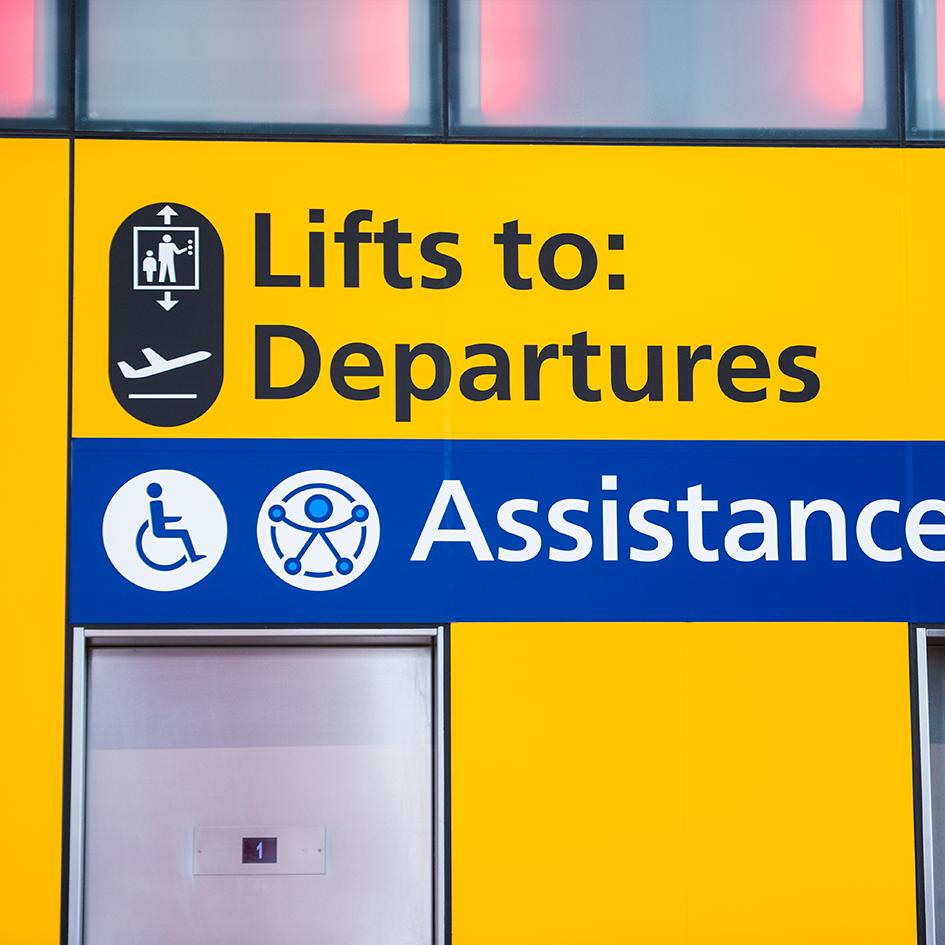 Blue sign that says 'assistance' and has a wheelchair icon