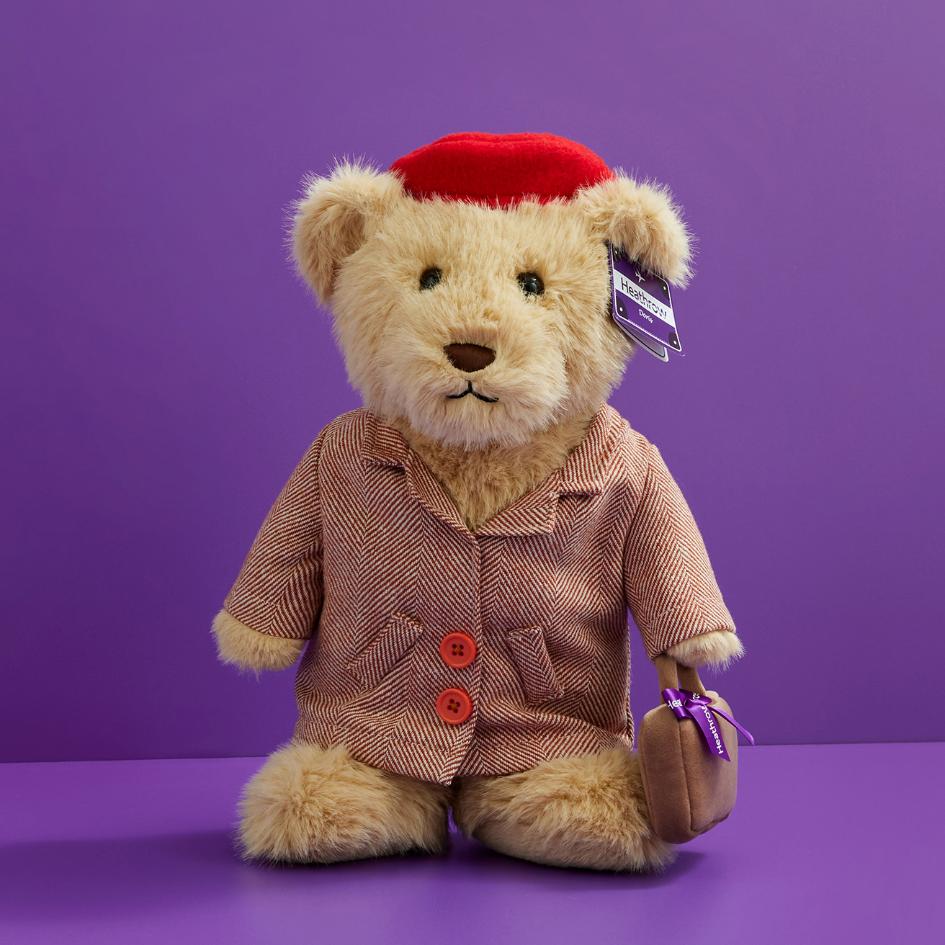 teddy bear wearing a pink coat and holding a handbag, available for purchase