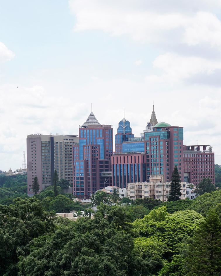 Stadium and skyscrapers including  Prestige UB City Concorde Block visible through greenery