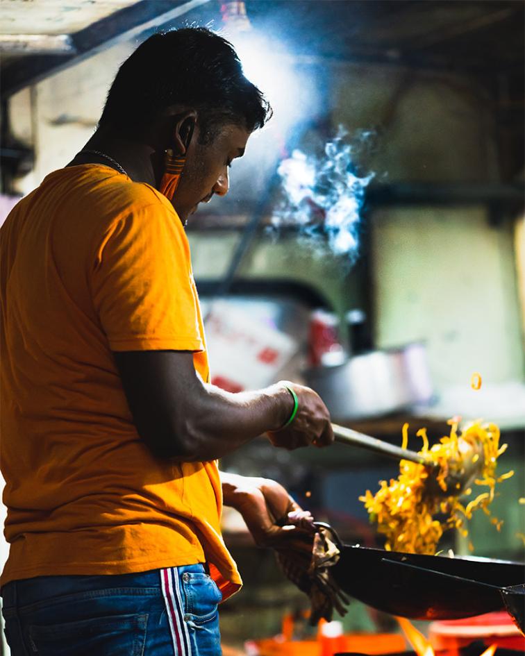 Man preparing fried potatoes outdoors in Bengaluru.